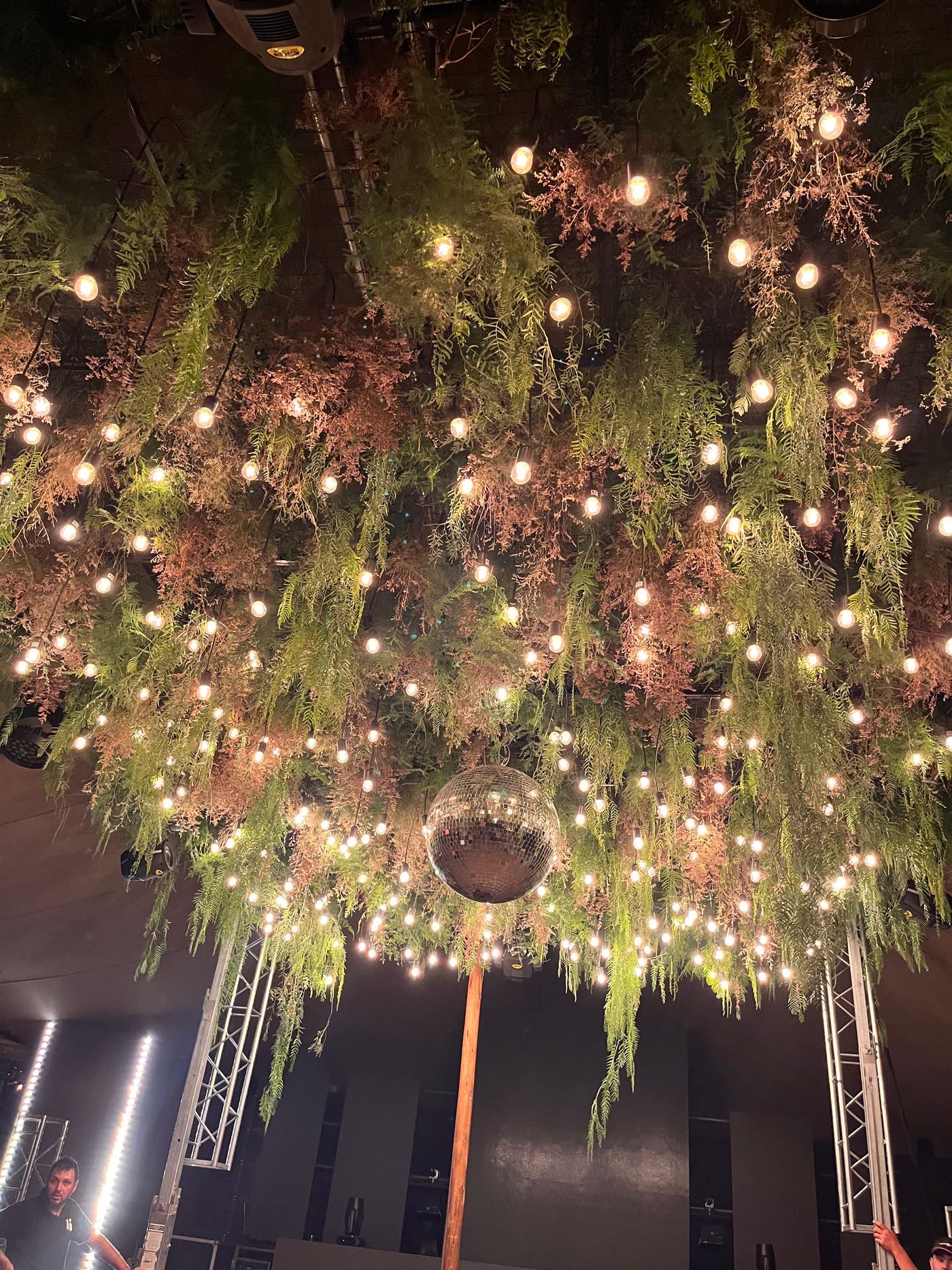 Instalación aérea Espejismo Cielo Tierra, follajes y luces colgantes para una boda